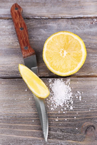 Bodegón con limón fresco, cuchillo y sal sobre una vieja mesa de madera — Foto de Stock