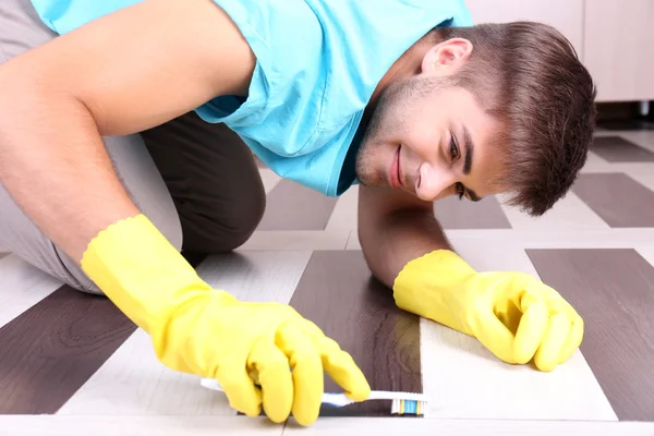 Jonge man schoonmaak vloer — Stockfoto