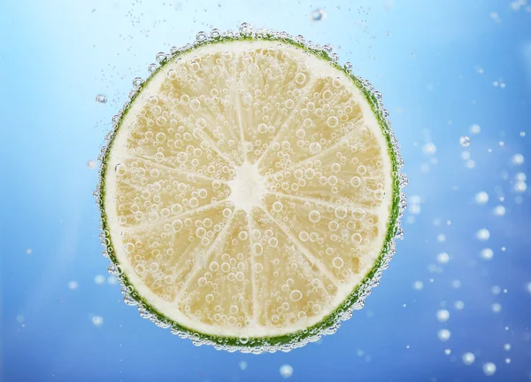 Fresh lime in water with bubbles — Stock Photo, Image