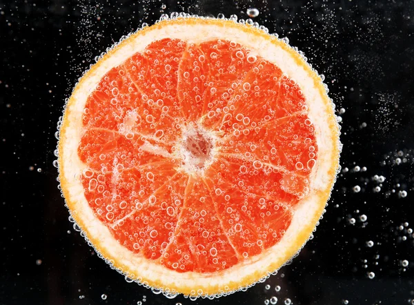 Fresh grapefruit in water bubbles — Stock Photo, Image