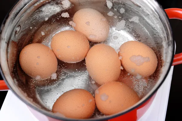 Huevos en agua hirviendo —  Fotos de Stock