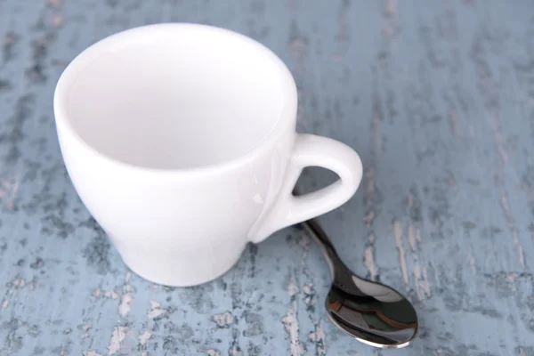 Empty cup with tea spoon on wooden background — Stock Photo, Image