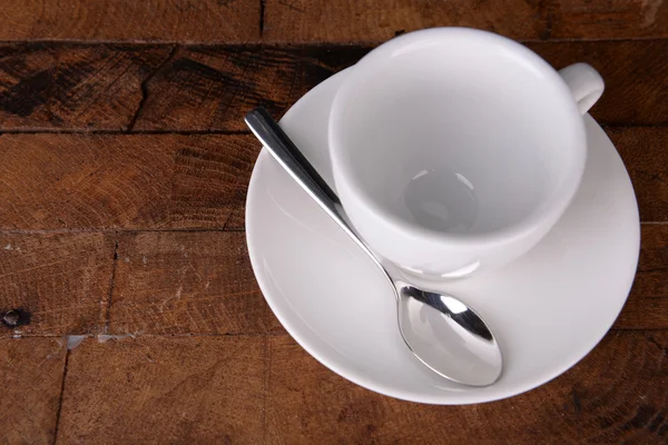 Empty cup with tea spoon on wooden background — Stock Photo, Image