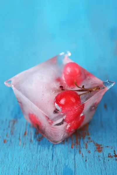 Buz küpleri ile ahşap arka plan üzerinde kırmızı kuş üzümü — Stok fotoğraf