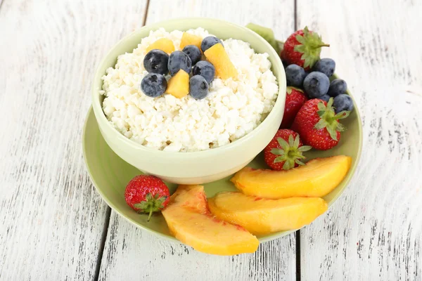 Queso de cabaña con frutas y bayas en tazón sobre mesa de madera — Foto de Stock