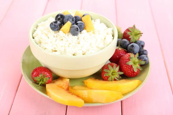 Queso de cabaña con frutas y bayas en tazón sobre mesa de madera —  Fotos de Stock