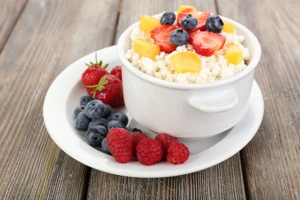 Cottage cheese with fruit and berry in bowl on wood table — Stok Foto