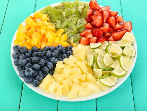Frutas fatiadas no prato na mesa de madeira — Fotografia de Stock
