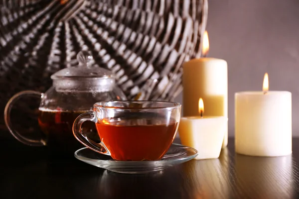 Composición con té en tetera de vidrio y velas en la mesa, sobre fondo oscuro — Foto de Stock