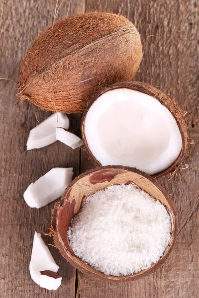 Розбитий кокос на дерев'яному фоні — стокове фото