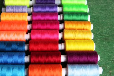 ahşap zemin üzerinde çok renkli dikiş ipliği