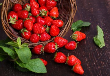 ahşap zemin üzerinde hasır sepet içinde Olgun tatlı çilek