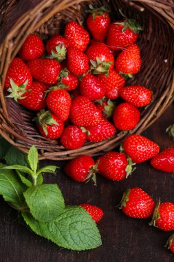 ahşap zemin üzerinde hasır sepet içinde Olgun tatlı çilek