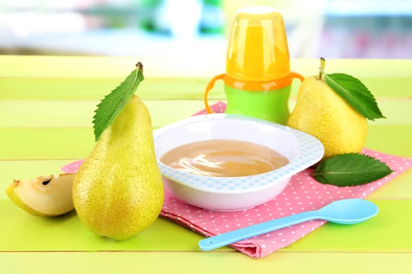 Saboroso purê de frutas do bebê e mamadeira na mesa de madeira — Fotografia de Stock