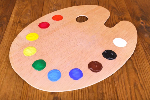 Wooden art palette with paint on table close-up — Stock Photo, Image