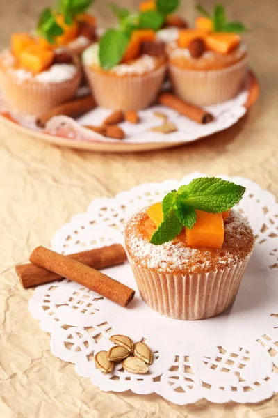 Tasty pumpkin muffins on brown paper — Stock Photo, Image