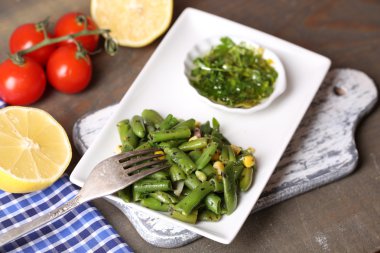 salata fasulye ve Mısır, plaka renk ahşap zemin üzerine sos ile