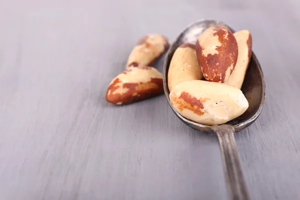 Винтажная ложка с вкусными бразильскими орехами на деревянном фоне — стоковое фото