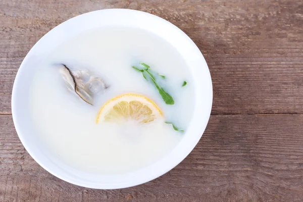 Tasty soup with oysters on wooden table — Stock Photo, Image