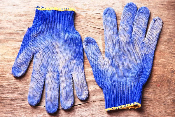 Dirty used fabric gloves on wooden background — Stock Photo, Image