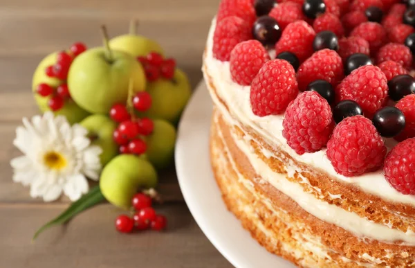 Smakelijke cake met verse bessen op houten tafel — Stockfoto