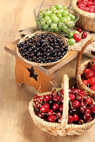 Frische Beeren im Korb auf Holzgrund — Stockfoto