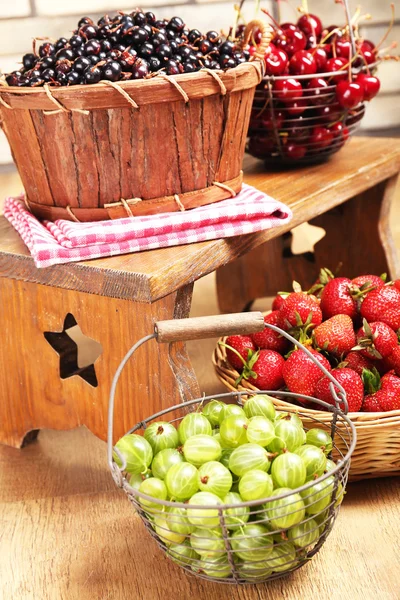 Frische Beeren im Korb auf Holzgrund — Stockfoto