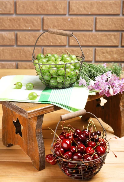 Frische Beeren in Körben auf Wandhintergrund — Stockfoto