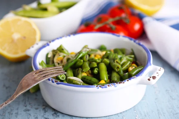 Insalata con fagiolini e mais, e salsa sul piatto, su sfondo di legno a colori — Foto Stock