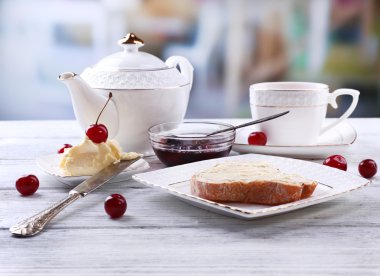 Parlak zemin üzerine ahşap masa üzerinde plaka üzerinde ev yapımı tereyağı ile taze ekmek