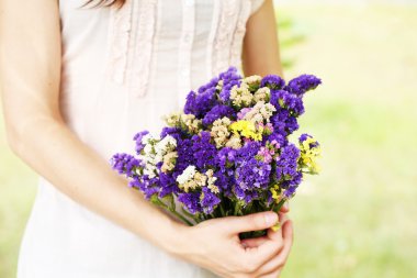 Kızın doğal zemin üzerine ellerinde çiçekler