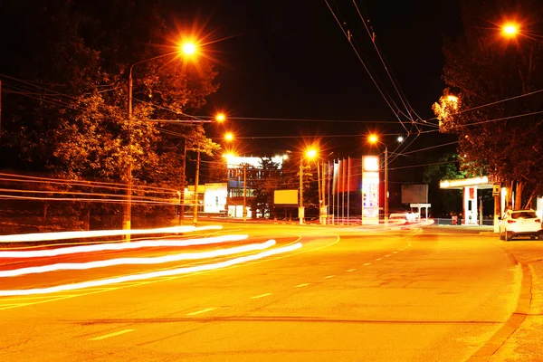 Automóvil en movimiento con luz borrosa a través de la ciudad por la noche — Foto de Stock