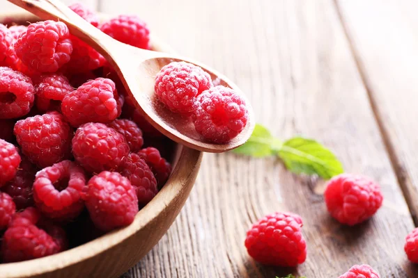 Ripe sweet raspberries in bowl on table close-up — Stock Photo, Image