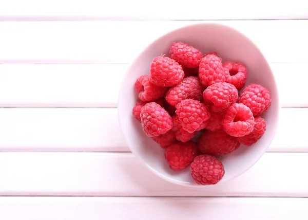 Frambuesas dulces maduras en tazón sobre la mesa de cerca — Foto de Stock