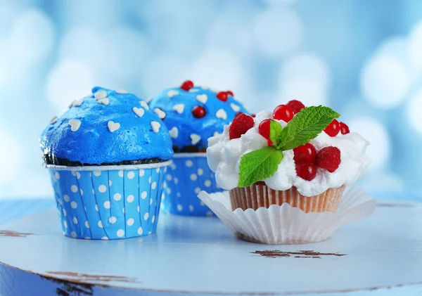Leckere Cupcakes auf dem Tisch, auf hellem Hintergrund — Stockfoto