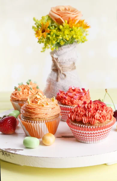 Tasty cupcakes on table, on bright background — Stock Photo, Image