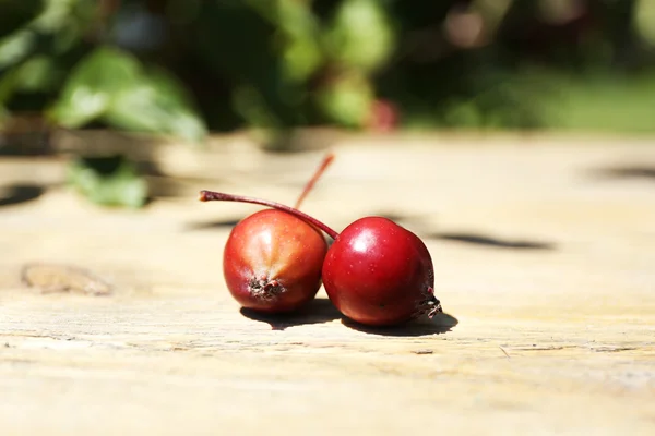 Jablka na dřevěný stůl v zahradě, venku — Stock fotografie