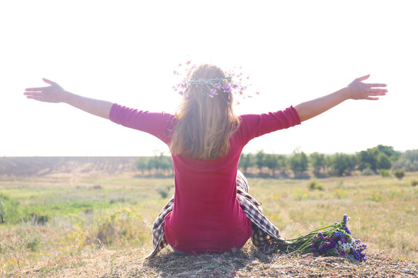 Woman waiting for summer sun on meadow
