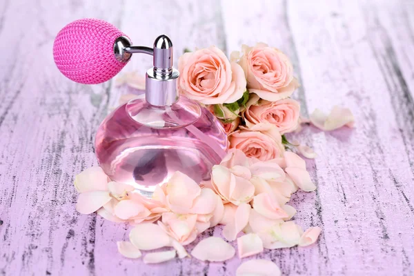 Perfume bottle with petals on table close-up — Stock Photo, Image