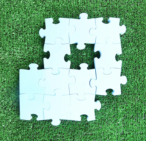 Puzzle pieces on green grass background. Green space concept — Stock Photo, Image