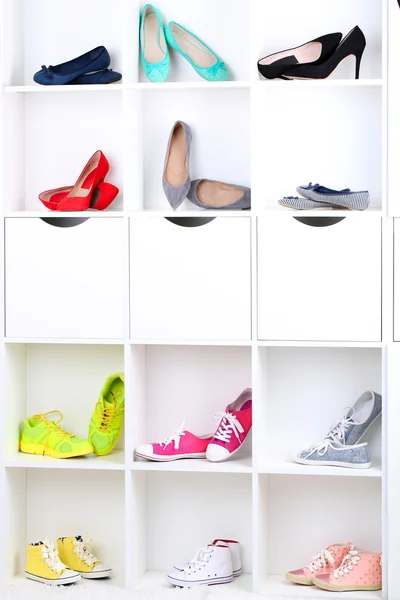 Colorful female shoes on wooden shelves — Stock Photo, Image