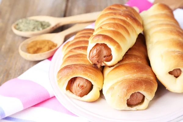 Rotoli di salsiccia al forno sul piatto primo piano del tavolo — Foto Stock