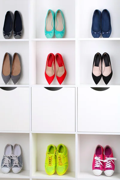 Zapatos femeninos coloridos en estantes de madera —  Fotos de Stock