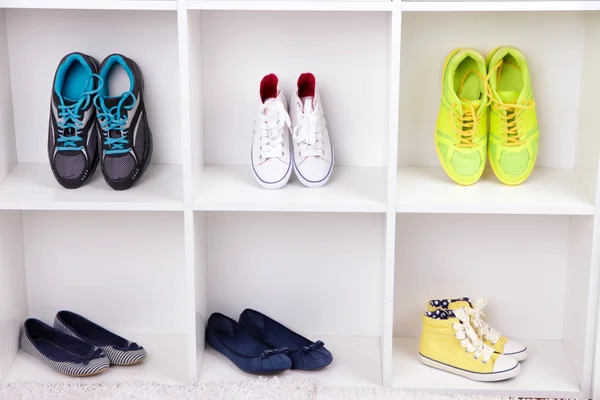 Colorful shoes on wooden shelves — Stock Photo, Image