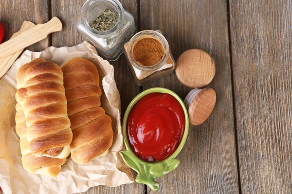 Baked sausage rolls on wooden table close-up — Stock Photo, Image