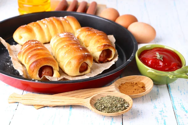 Baked sausage rolls in pan on table close-up — Stock Photo, Image