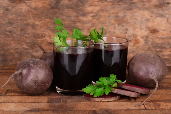 Glasses of fresh beet juice and vegetables on wooden background — Stock Photo, Image