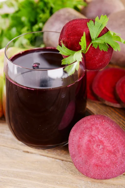 Copo de suco de beterraba fresca e legumes em fundo de madeira — Fotografia de Stock