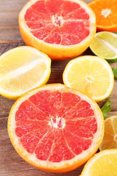 Olika skivad saftiga citrusfrukter på träbord — Stockfoto