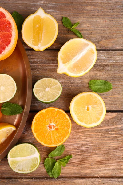 Verschillende gesneden sappige citrusvruchten op houten tafel — Stockfoto